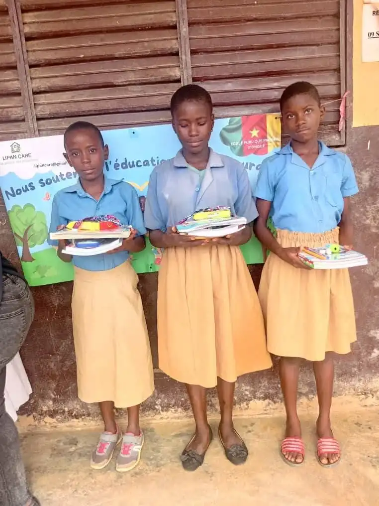 Trois élèves en uniforme avec leurs kits scolaires